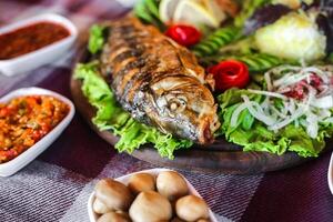 bord van vis, salade, en sauzen met kleurrijk presentatie foto