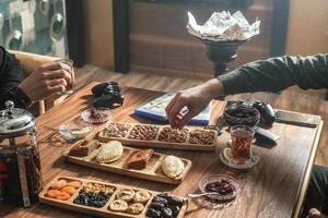 paar zittend Bij buitenshuis tafel met drankjes en gesprek foto