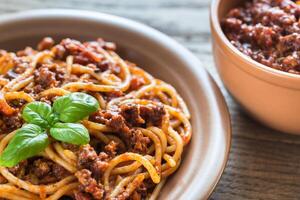 spaghetti met bolognese saus Aan de houten achtergrond foto