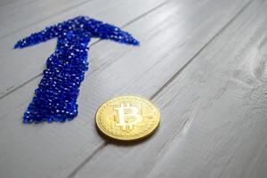 gouden bitcoin en blauw pijl Aan een wit achtergrond. foto