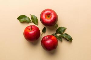 veel rood appels Aan gekleurde achtergrond, top visie. herfst patroon met vers appel bovenstaand visie met kopiëren ruimte voor ontwerp of tekst foto