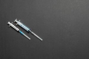 top visie van injectiespuiten in een rij voor medisch injectie Aan kleurrijk achtergrond met kopiëren ruimte. Gezondheid en vaccinatie concept foto