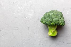 top visie vers groen broccoli groente Aan gekleurde achtergrond. broccoli kool hoofd gezond of vegetarisch voedsel concept. vlak leggen. kopiëren ruimte foto