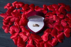 verloving ring in een rood doos Aan een liefde harten achtergrond. foto