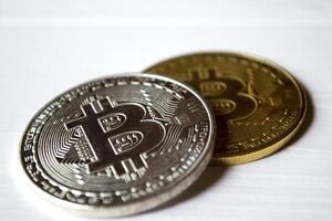 zilver en gouden bitcoins Aan een wit achtergrond. foto