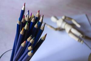 gekleurde potloden, leeg papier en dummy voor tekening Aan de tafel. foto