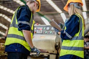 arbeider timmerlieden werken in machines naar besnoeiing hout hout. Mens en vrouw zijn bouwen met hout in een werkplaats. twee ambachtslieden of klusjesmannen werken met timmerman gereedschap of elektrisch machines. foto