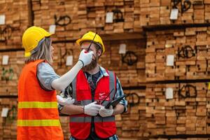 arbeiders timmerman vervelend veiligheid uniform en moeilijk hoed werken en controle de kwaliteit van houten producten Bij werkplaats productie. Mens en vrouw arbeiders hout in donker magazijn industrie. foto