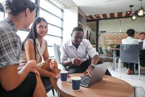 verschillend medewerkers verzameld in kantoor hebben pret gedurende brainstorming terwijl bespreken nieuw ideeën project. multiraciaal collega's vergadering Bij coworking ruimte Oppervlakte. team van jong mensen in kantoor. foto