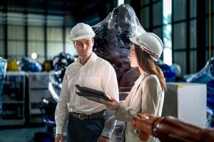 bedrijf ingenieurs vergadering en controle nieuw machine robot. arbeiders wandelen Bij magazijn industrie lassen machine. bedrijf onderhandeling concepten en technologie. Dames gebruik makend van slim tablet naar Cadeau Mens. foto