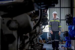 fabriek ingenieur vrouw inspecteren Aan machine met slim tablet. arbeider werken Bij machine robot arm. de lassen machine met een afgelegen systeem in een industrieel fabriek. kunstmatig intelligentie- concept. foto