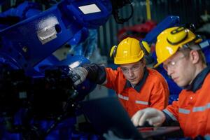 bedrijf ingenieurs ontmoeten en controleren controle zwaar machine robot arm. verschillend team van industrieel robotica ingenieurs verzameld in de omgeving van machine. professioneel machinerie operator gebruik industrieel digitaal tablet. foto