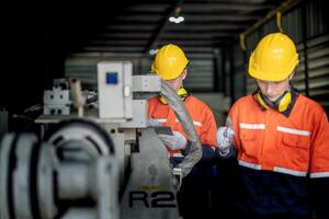 ingenieur Mens controle de toestand van machine en gebruikt moersleutel naar schroef sommige een deel van uitrusting Bij cnc fabriek. arbeider vervelend veiligheid bril en helm. onderhoud en repareren concept. foto