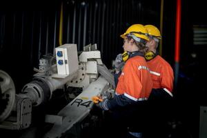 mannetje ingenieur arbeiders onderhoud automatisch robot arm machine in een fabriek. arbeider controle en repareren automatisch robot hand- machine. technicus arbeider controleren voor reparatie fabriek machine. foto