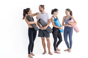 groep van gelukkig sportief meisjes en vent vervelend lichaam elegant sportkleding Holding persoonlijk tapijten leunde Aan een wit achtergrond. aan het wachten voor yoga klasse of lichaam gewicht klas. gezond levensstijl en welzijn foto