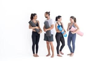 groep van gelukkig sportief meisjes en vent vervelend lichaam elegant sportkleding Holding persoonlijk tapijten leunde Aan een wit achtergrond. aan het wachten voor yoga klasse of lichaam gewicht klas. gezond levensstijl en welzijn foto