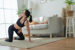 dichtbij omhoog Dames zelfverzekerd opleiding yoga. atletisch Dames in sportkleding aan het doen geschiktheid uitrekken opdrachten Bij huis in de leven kamer. sport en recreatie concept. yoga leraar is helpen meisje. foto