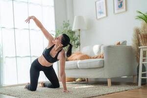 dichtbij omhoog Dames zelfverzekerd opleiding yoga. atletisch Dames in sportkleding aan het doen geschiktheid uitrekken opdrachten Bij huis in de leven kamer. sport en recreatie concept. yoga leraar is helpen meisje. foto