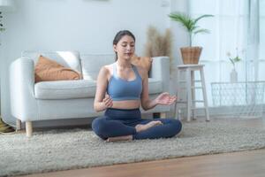 twee Dames zelfverzekerd opleiding yoga. atletisch Dames in sportkleding aan het doen geschiktheid uitrekken opdrachten Bij huis in de leven kamer. sport en recreatie concept. yoga leraar is helpen jong vrouw. foto