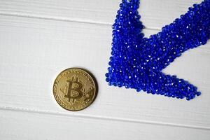 gouden bitcoin en blauw pijl Aan een wit achtergrond. foto
