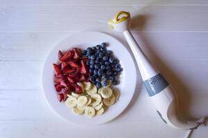bord met bananen, aardbeien en bosbessen. foto