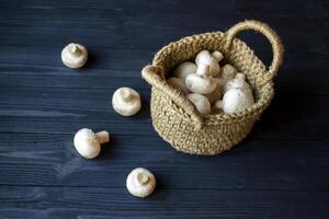 de champignons in een mand Aan een houten tafel. foto