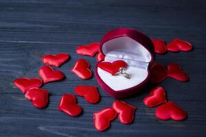 verloving ring in een rood doos Aan een liefde harten achtergrond. foto