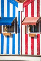 kleurrijk gestreept vissers huizen in blauw en rood, costa nieuw, aveiro, Portugal foto