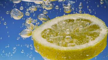 onderwater- citroen plak in Frisdrank water of limonade met bubbels. foto