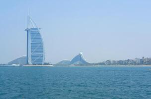 de iconisch burj al Arabisch staat hoog naast luxe aan het strand resorts Aan een Doorzichtig dag in van Dubai zeegezicht. dubai, uae - augustus 15, 2023 foto