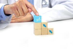 vinger van dokter aanraken een houten blok kubus met medisch icoon symbool. medisch, Gezondheid en verzekering concept. foto