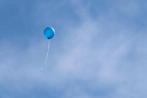 blauw helium gevulde partij ballonnen drijvend in lucht foto