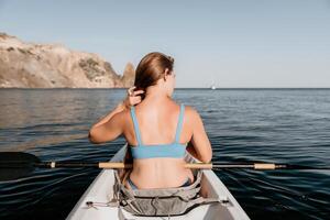 vrouw in kajak terug visie. gelukkig jong vrouw met lang haar- drijvend in kajak Aan kalmte zee. zomer vakantie vakantie en vrolijk vrouw mensen ontspannende hebben pret Aan de boot. foto