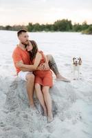 jong stel in oranje kleren met hond foto