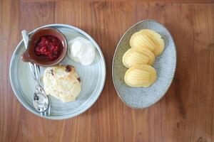 madeleine of madeleines en scone , veenbes scone of scone met geslagen room en BES saus foto