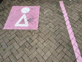 bestrating blok parkeren met uniek roze parkeren lijnen en symbool in rust uit gebieden foto