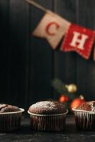 chocola muffins met gepoederd suiker Aan top Aan een zwart achtergrond. Kerstmis decoratie . nog steeds leven dichtbij omhoog. voedsel foto