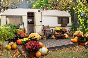 mobiel huis busje met terras in herfst, mobiel huis, oranje gedaald bladeren. herfst decor, pompoenen foto
