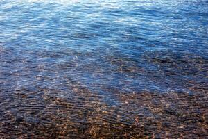 achtergrond van de water van meer Traunsee in de kust- Oppervlakte. kleurrijk structuur van stenen onder water. foto