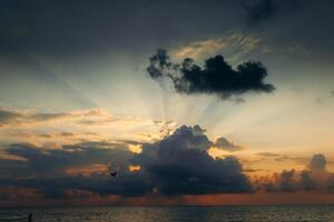 zonsondergang met wolken, licht stralen en andere sfeervol effect. dramatisch bewolkt horizon foto