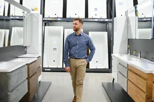 Mens kiezen nieuw badkamer meubilair Bij de loodgieter winkel met veel van sanitair goederen foto