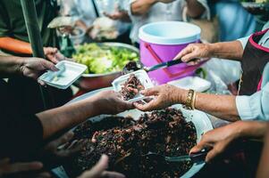 arm mensen te ontvangen gedoneerd voedsel van donateurs de handen van de arm te ontvangen voedsel van de handen van de humaan foto