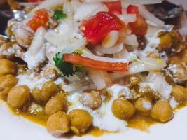 chole samosa chaat met yoghurt, ui en aardappelen. populair straat voedsel in Indië en Pakistan foto