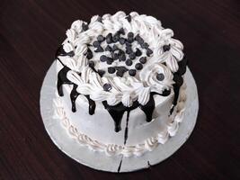 heerlijk verjaardag taart met wit room en chocola Aan houten tafel top visie - zoet toetje foto