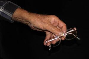 bril en senior man's handen foto