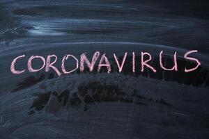 het uitbreken waarschuwing. geschreven wit krijt Aan schoolbord in verbinding met epidemie van coronavirus wereldwijd. foto