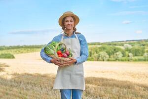 vrouw boer rietje hoed schort staand bouwland glimlachen vrouw agronoom specialist landbouw agribusiness gelukkig positief Kaukasisch arbeider agrarisch veld- foto