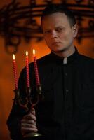 portret van knap Katholiek priester of voorganger met hond halsband, donker rood achtergrond. foto