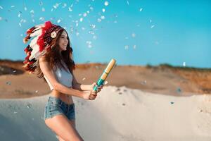 een mooi jong Kaukasisch meisje in een wit top en denim shorts Aan haar hoofd is vervelend een Indisch hoed. kakkerlak is in de woestijn. gelukkig vakantie humeur. foto