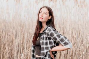 gelukkig jong glimlachen vrouw met sproeten buitenshuis portret. zacht zonnig kleuren. buitenshuis detailopname portret van een jong brunette vrouw en op zoek naar de camera, poseren tegen herfst natuur achtergrond foto